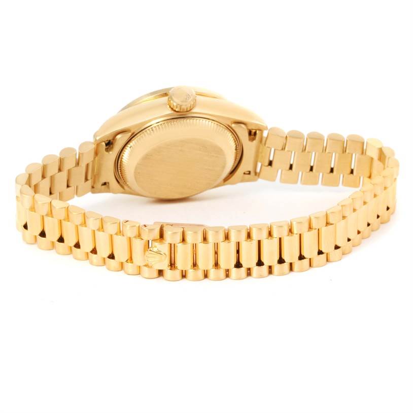 The image shows the back view of a Rolex President 69178 Women's Yellow Gold Black Dial 69178 Women's Yellow Gold Black Dial model watch, highlighting its gold case, crown, and bracelet.