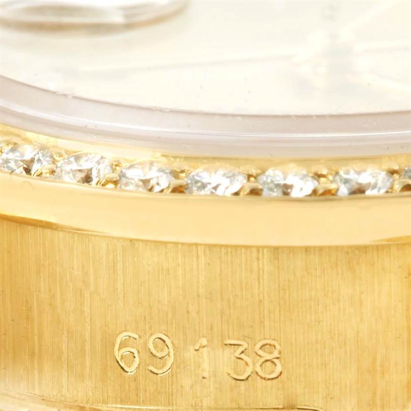 This close-up angle shows the bezel with diamonds and part of the case from a Rolex President 69178 Women's Yellow Gold Champagne Dial 69178 Women's Yellow Gold Champagne Dial watch model, featuring its engraved model number.