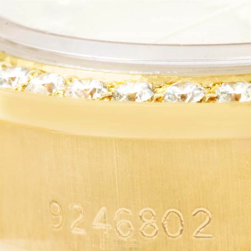 This close-up image of a Rolex President 69178 Women's Yellow Gold Champagne Dial 69178 Women's Yellow Gold Champagne Dial model shows the serial number inscribed on the gold casing and the diamond-set bezel.