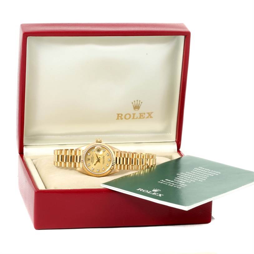 The Rolex President 69178 Women
s Yellow Gold Champagne Dial 69178 Women
s Yellow Gold Champagne Dial model watch is shown from the front in its open box, accompanied by a green booklet.