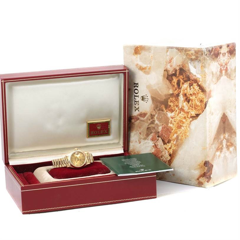 The image shows a Rolex President 69178 Women
s Yellow Gold Champagne Dial 69178 Women
s Yellow Gold Champagne Dial model watch in its box with accompanying booklet and outer packaging.