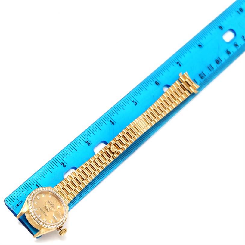 The image shows a Rolex President 69178 Women's Yellow Gold Champagne Dial 69178 Women's Yellow Gold Champagne Dial watch laid flat next to a ruler, highlighting the watch's face, bezel, and entire bracelet.