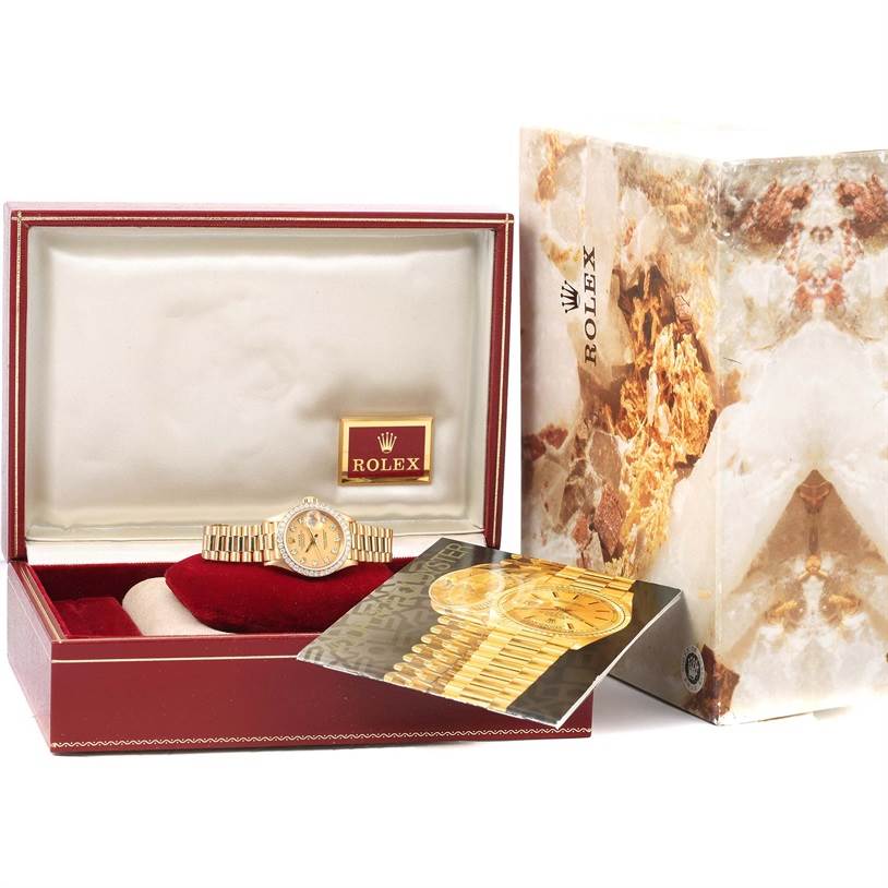 The image shows a Rolex President 69178 Women's Yellow Gold Champagne Dial 69178 Women's Yellow Gold Champagne Dial model watch inside an open box, alongside a booklet and outer box.