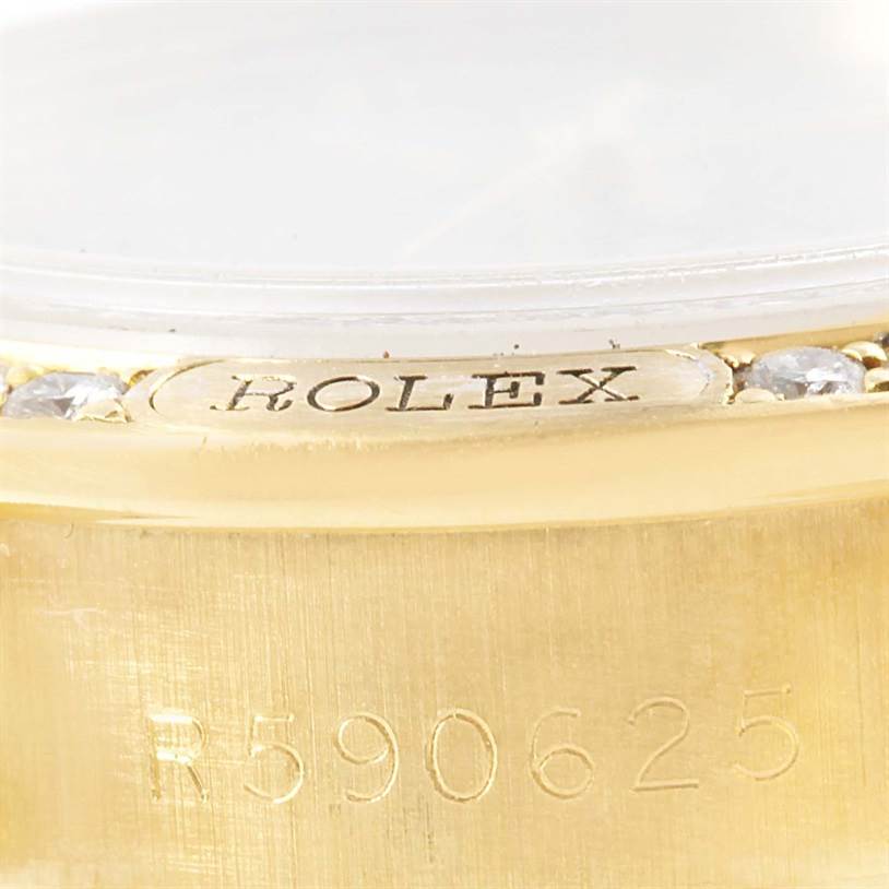 This close-up image shows the serial number and part of the bezel of a Rolex President 69158 Women's Yellow Gold Mother of Pearl Dial 69158 Women's Yellow Gold Mother of Pearl Dial model watch.