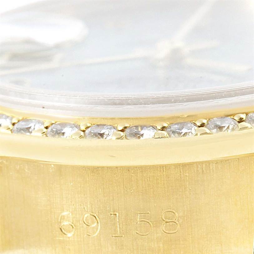 This image shows a close-up of the side of a Rolex President 69158 Women's Yellow Gold Mother of Pearl Dial 69158 Women's Yellow Gold Mother of Pearl Dial model watch, highlighting the bezel with diamonds and part of the case, including the serial number "69158".