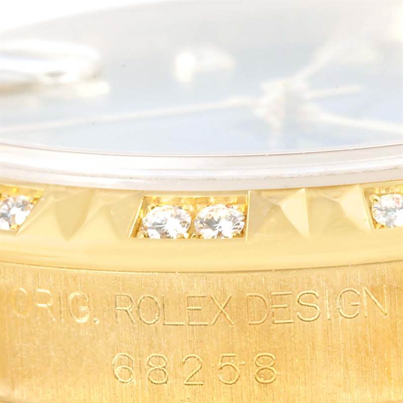 This close-up image of the Rolex President 68258 Women's Yellow Gold Blue Dial 68258 Women's Yellow Gold Blue Dial model shows part of the dial, bezel with diamonds, and engraved model number.