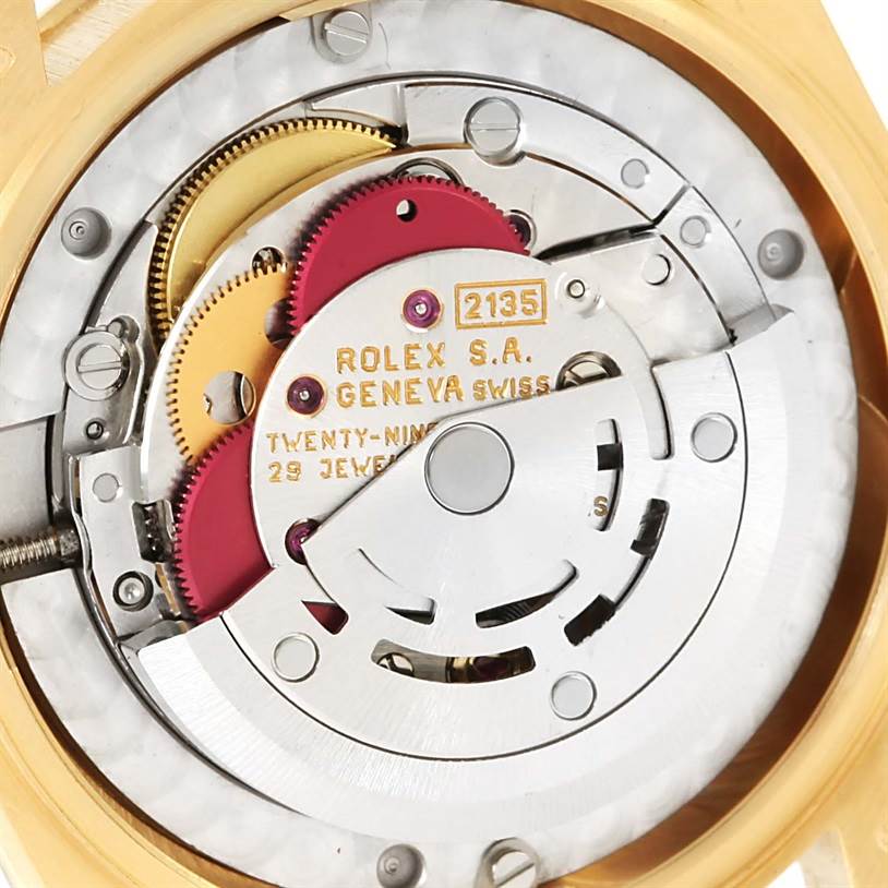The image shows a close-up view of the movement inside a Rolex President 68258 Women's Yellow Gold Blue Dial 68258 Women's Yellow Gold Blue Dial model watch, including gears and the rotor.