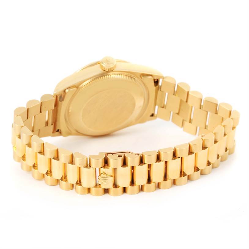 The image shows the President model by Rolex from a rear angle, highlighting the case back and gold bracelet.