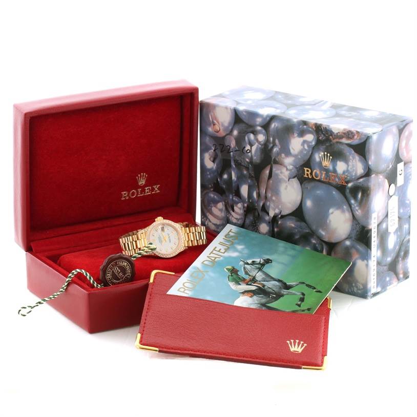 The image shows a Rolex President 69158 Women's Yellow Gold Mother of Pearl Dial 69158 Women's Yellow Gold Mother of Pearl Dial model watch in a red presentation box, with its original box, booklet, and tag.