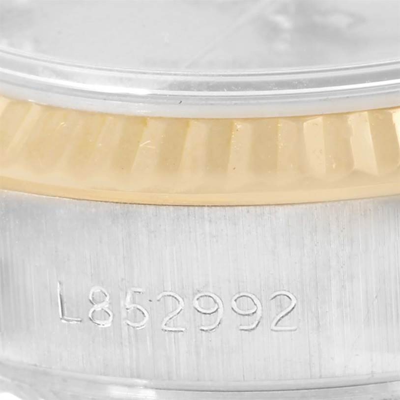 This image shows the side profile of a Rolex President 69179 Women's White Gold Brown Dial 69179 Women's White Gold Brown Dial model watch, highlighting the bezel and part of the casing with an engraving.