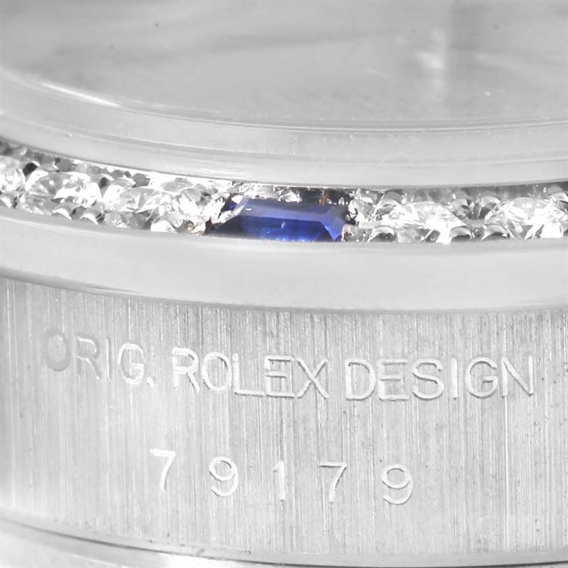 The image shows a close-up of the bezel and part of the case back of a Rolex President 79179 Women's White Gold Silver Dial 79179 Women's White Gold Silver Dial model watch, highlighting the diamonds and engraving.