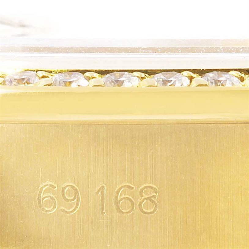 This image shows a close-up of the Rolex President 69168 Women's Yellow Gold Champagne Dial 69168 Women's Yellow Gold Champagne Dial model watch's bezel with diamonds and its model number, 69168.