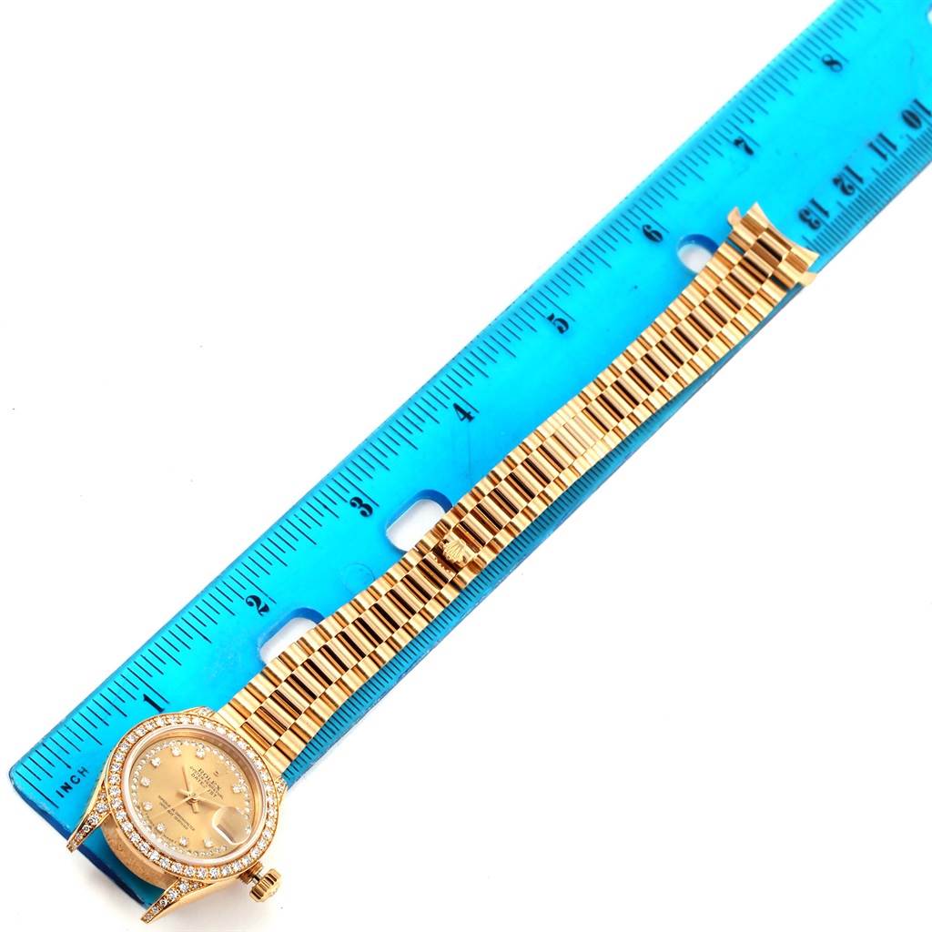 The Rolex President 69158 Men
s Yellow Gold Champagne Dial 69158 Men
s Yellow Gold Champagne Dial model watch is shown from an overhead view, with the bracelet extended alongside a ruler.