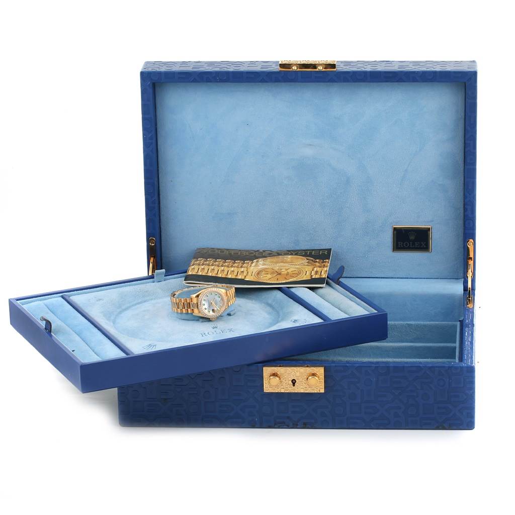 The image shows a Rolex President 179138 Women's Yellow Gold Mother of Pearl Dial 179138 Women's Yellow Gold Mother of Pearl Dial watch and accessories from a front angle inside an open blue watch box.