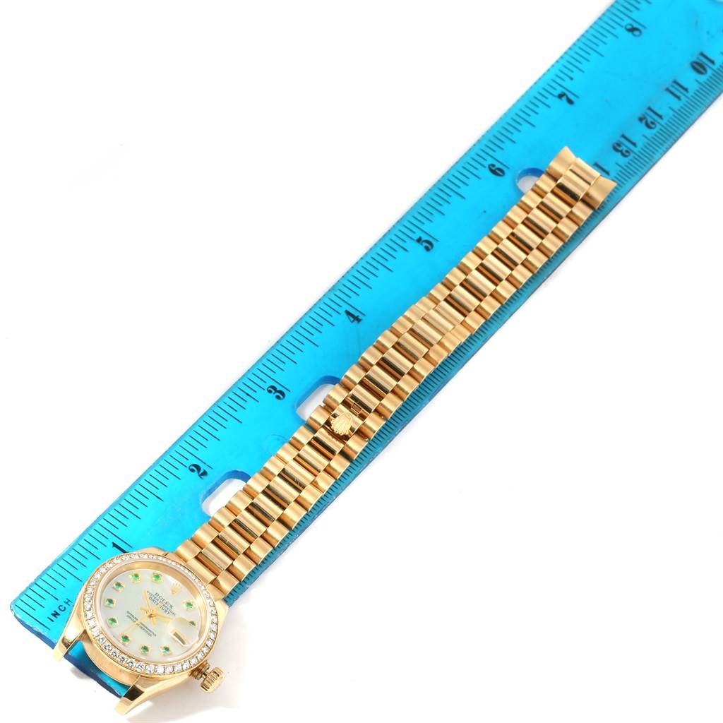 The image shows a Rolex President 179138 Women's Yellow Gold Mother of Pearl Dial 179138 Women's Yellow Gold Mother of Pearl Dial model watch laid flat, with a focus on its gold bracelet and face, next to a ruler for scale.