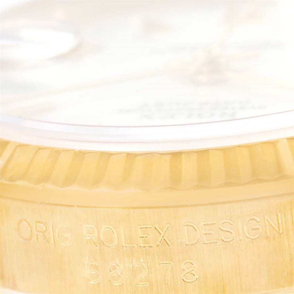 The image shows a close-up of the Rolex President 68278 Women's Yellow Gold White Dial 68278 Women's Yellow Gold White Dial model, focusing on the fluted bezel and case with engraved serial number.