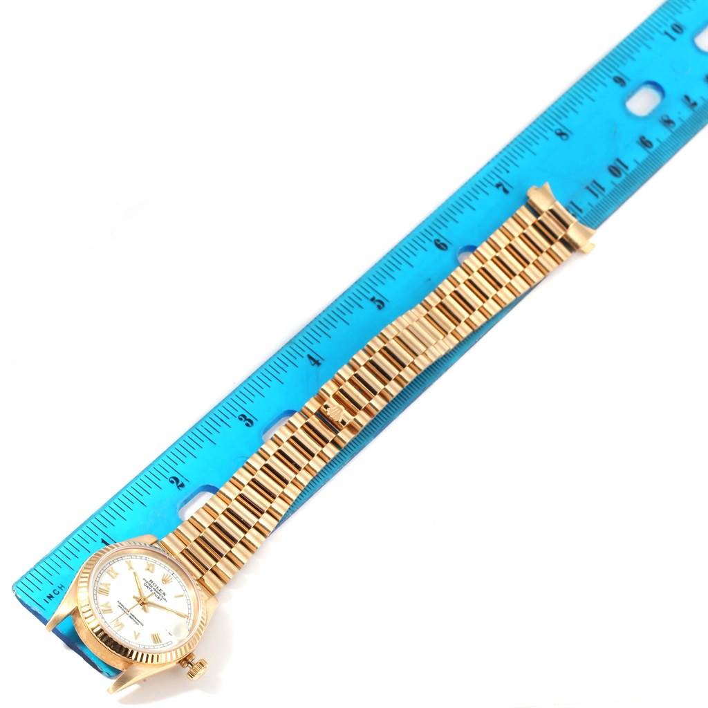 The image shows a Rolex President 68278 Women's Yellow Gold White Dial 68278 Women's Yellow Gold White Dial model watch placed alongside a blue ruler for measurement.