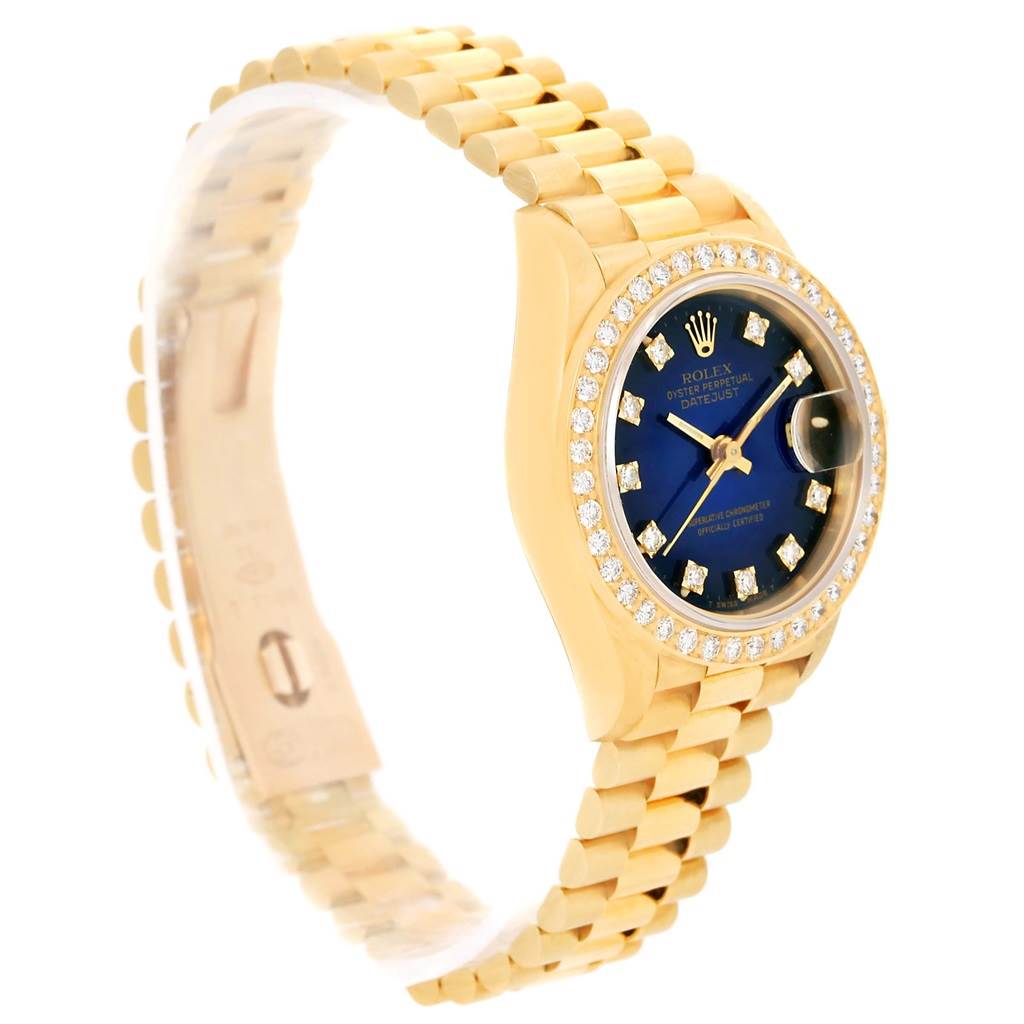 The Rolex President 69138 Women's Yellow Gold Blue Dial 69138 Women's Yellow Gold Blue Dial model watch is shown at an angled side view, displaying its gold bracelet, blue dial, and diamond bezel.