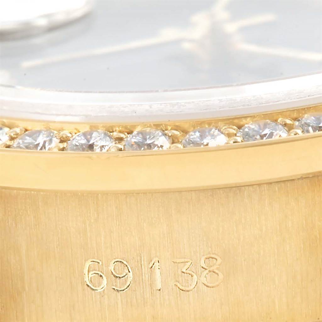 The image shows a close-up of the bezel and serial number of a Rolex President 69138 Women's Yellow Gold Blue Dial 69138 Women's Yellow Gold Blue Dial model, featuring diamonds.
