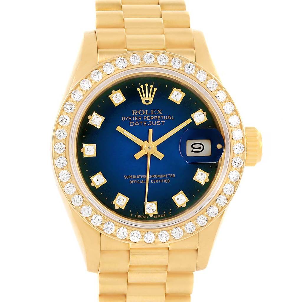 The image shows a frontal view of a Rolex President 69138 Women's Yellow Gold Blue Dial 69138 Women's Yellow Gold Blue Dial model watch, highlighting its gold band, diamond bezel, and blue dial with date display.