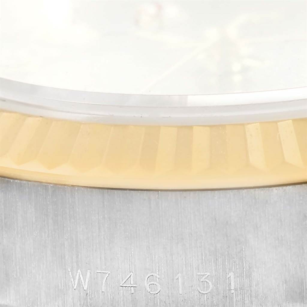 Close-up of a Rolex President 69179 Women's White Gold Silver Dial 69179 Women's White Gold Silver Dial watch showing the gold fluted bezel, part of the dial, and serial number inscription on the case.