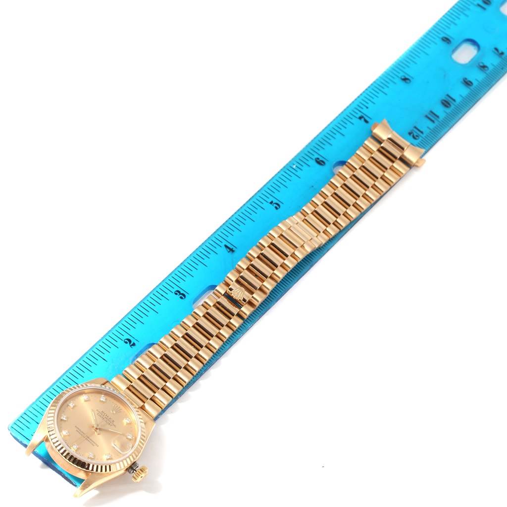 The image shows a Rolex President 68278 Women's Yellow Gold Champagne Dial 68278 Women's Yellow Gold Champagne Dial model watch laid flat alongside a blue ruler for size reference.