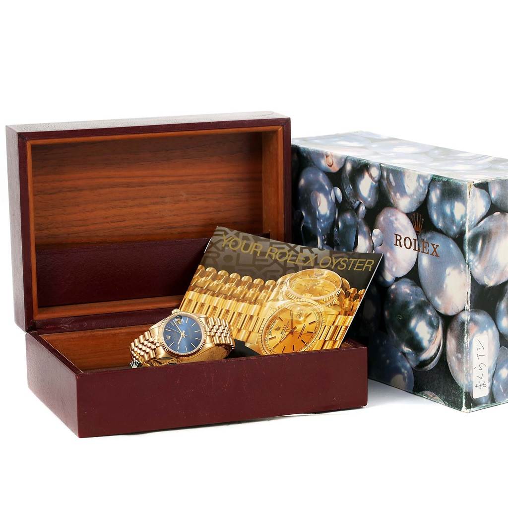 The image features a Rolex President 68278 Women's Yellow Gold Blue Dial 68278 Women's Yellow Gold Blue Dial watch with a golden band, displayed in an open wooden box along with a booklet.