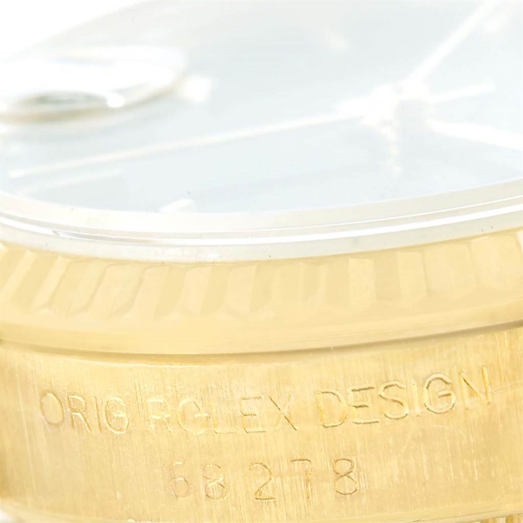 The image shows a close-up of the side of a Rolex President 68278 Women's Yellow Gold Blue Dial 68278 Women's Yellow Gold Blue Dial watch, highlighting its gold case and engraved text.