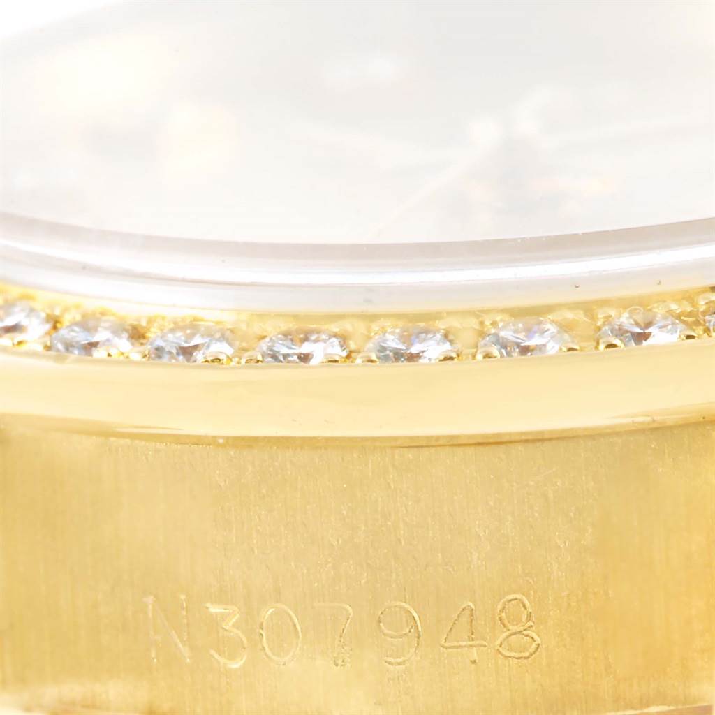 The image shows a close-up of the bezel and part of the case of a Rolex President 69138 Women's Yellow Gold Champagne Dial 69138 Women's Yellow Gold Champagne Dial model watch featuring diamonds.