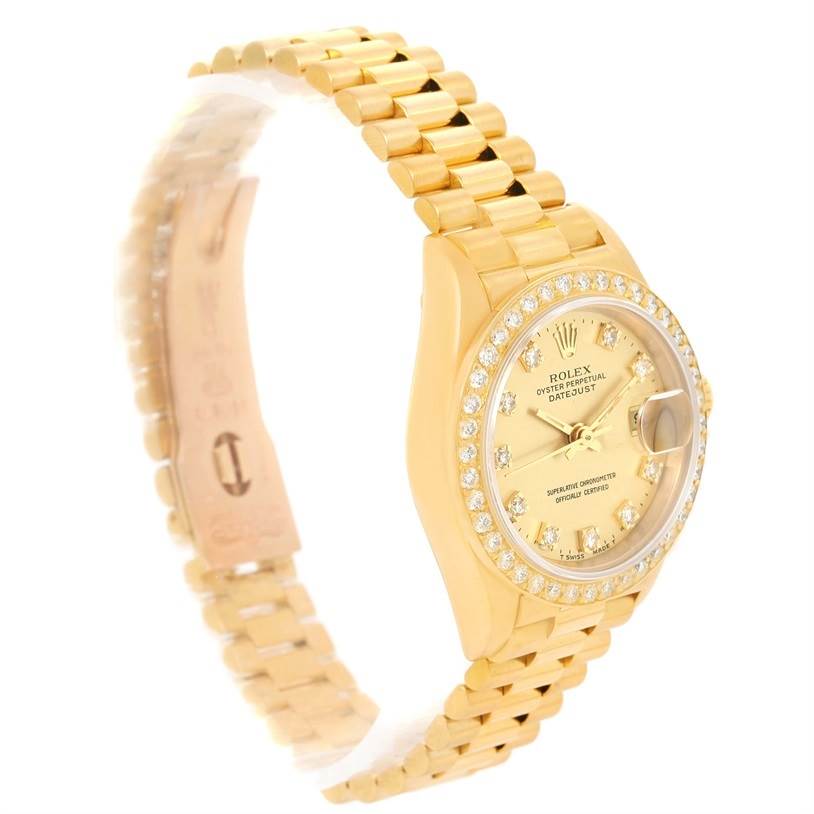 The image shows a Rolex President 69138 Women's Yellow Gold Champagne Dial 69138 Women's Yellow Gold Champagne Dial model watch from a front angle, showcasing its gold band, diamond-studded bezel, and dial.