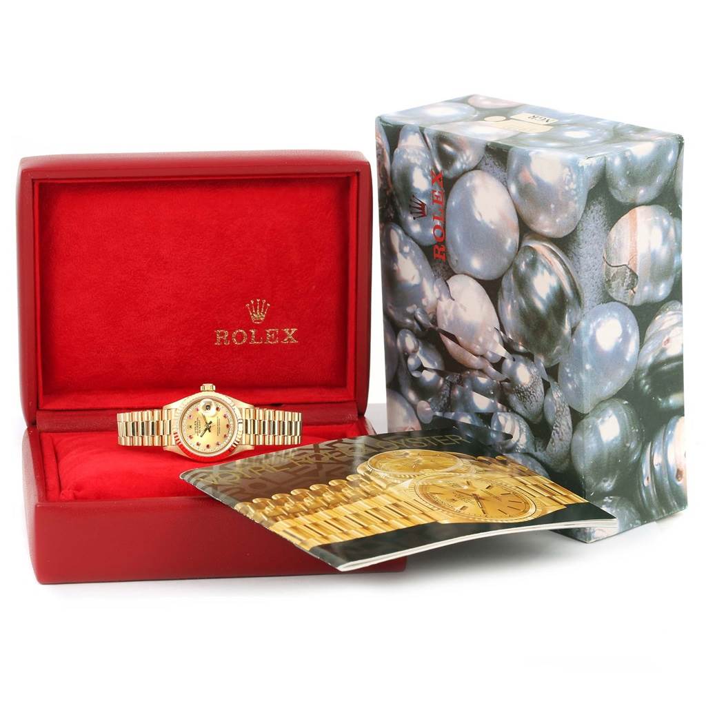 The Rolex President 69178 Women's Yellow Gold Champagne Dial 69178 Women's Yellow Gold Champagne Dial watch is shown from the front inside a red box, alongside its outer decorative box and a booklet.