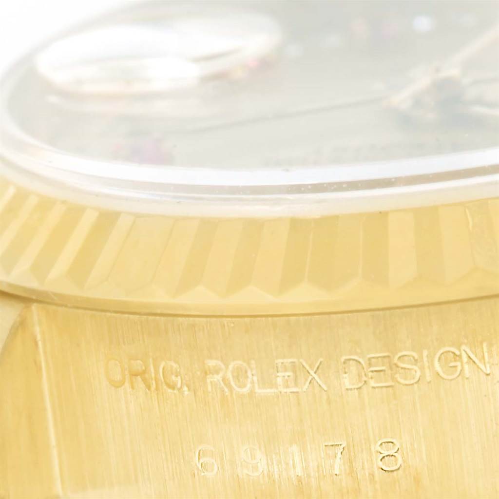 A close-up angle of the Rolex President 69178 Women's Yellow Gold Champagne Dial 69178 Women's Yellow Gold Champagne Dial model shows the edge of the dial, crystal, and engraved case with "ORIG. ROLEX DESIGN."