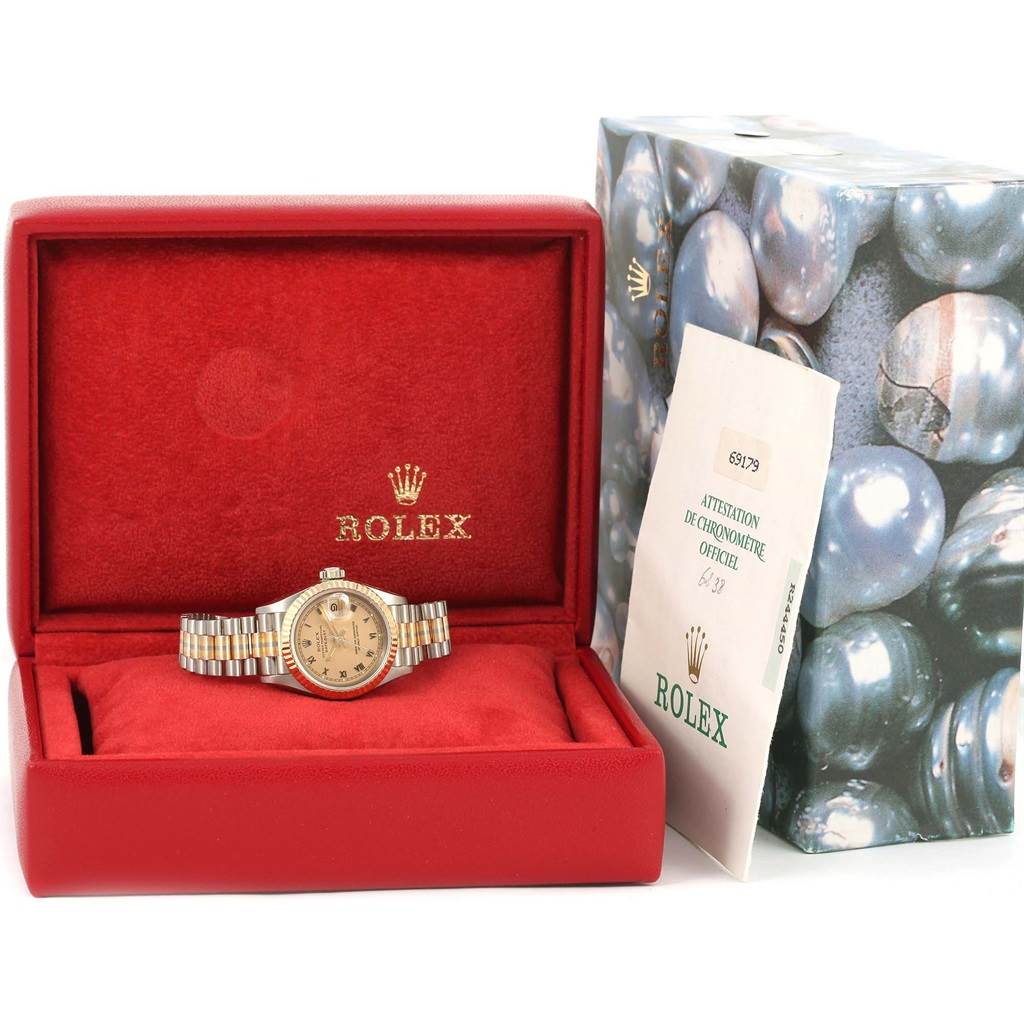 The Rolex President 69179 Women's White Gold Brown Dial 69179 Women's White Gold Brown Dial model watch is displayed front-on in an open red case with an accompanying official document.