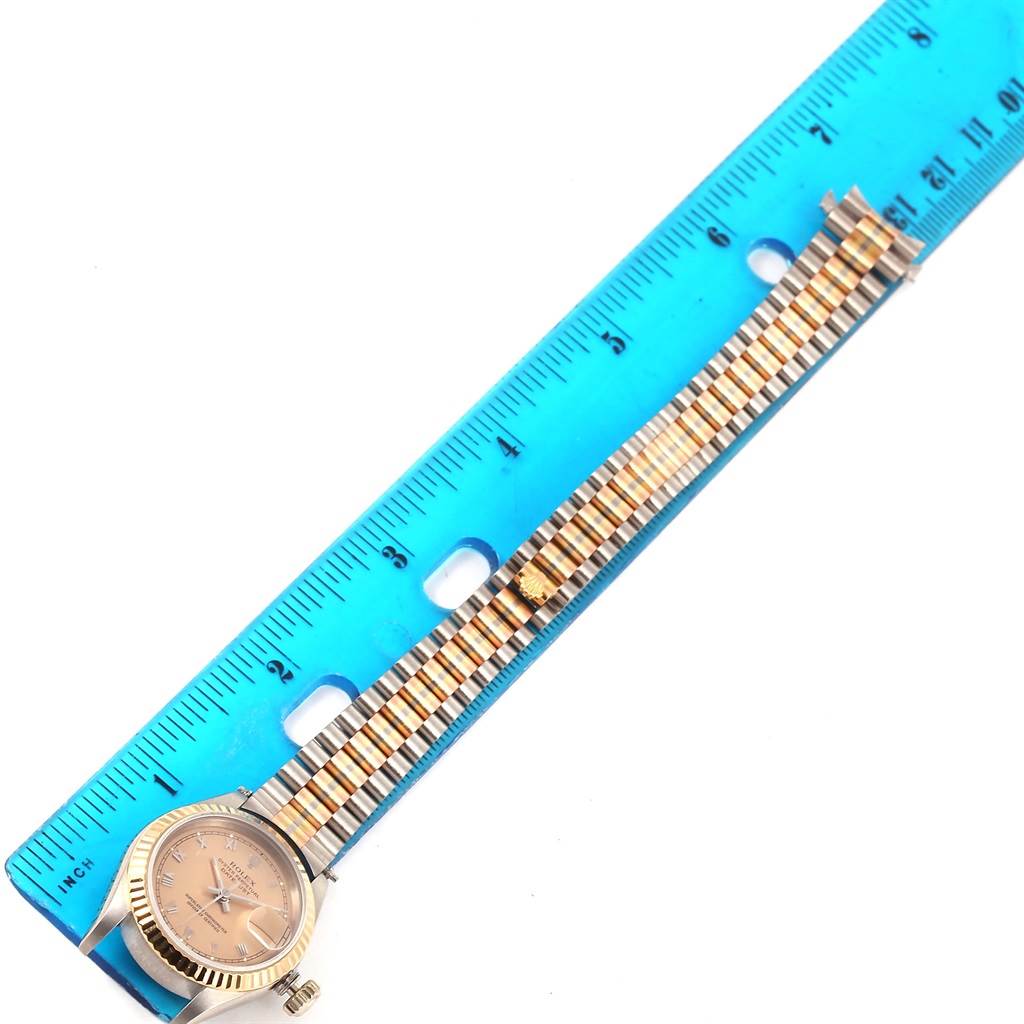 The image shows a Rolex President 69179 Women's White Gold Brown Dial 69179 Women's White Gold Brown Dial model watch placed next to a ruler for measurement, displaying the watch face and band.