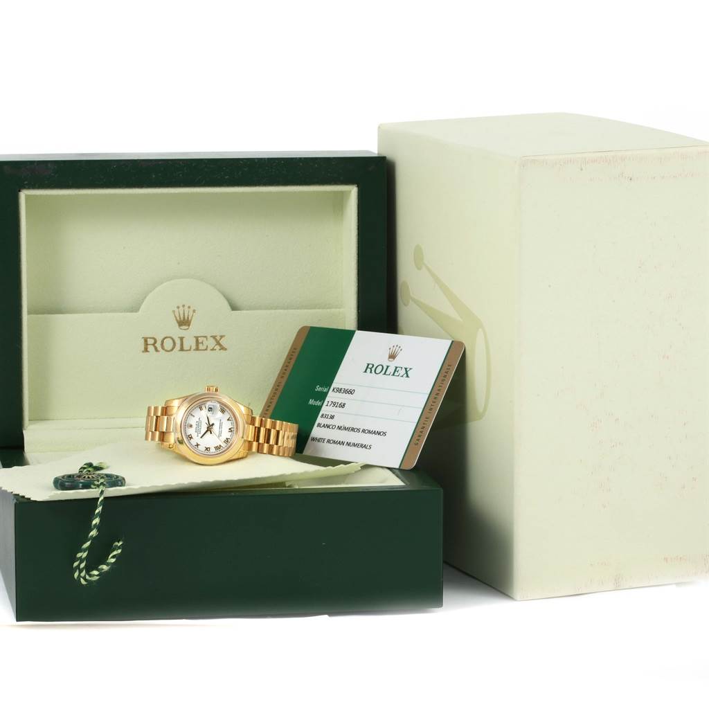 The image shows a Rolex President 179168 Women's Yellow Gold White Dial 179168 Women's Yellow Gold White Dial model watch with its box and authenticity card, viewed from the front.