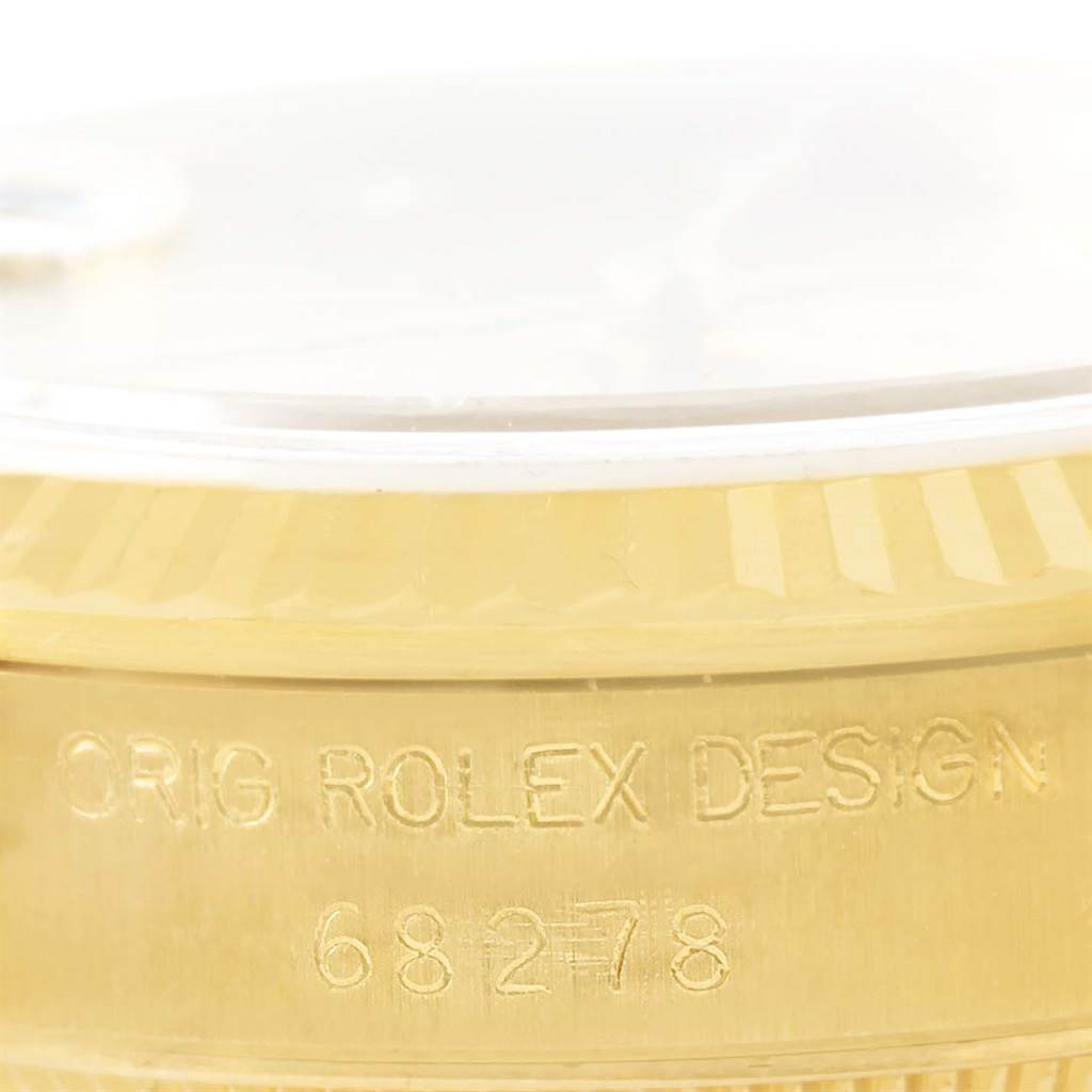 This close-up of a Rolex President 68278 Women's Yellow Gold Champagne Dial 68278 Women's Yellow Gold Champagne Dial watch shows the engraved text "ORIG ROLEX DESIGN 68278" on the case.