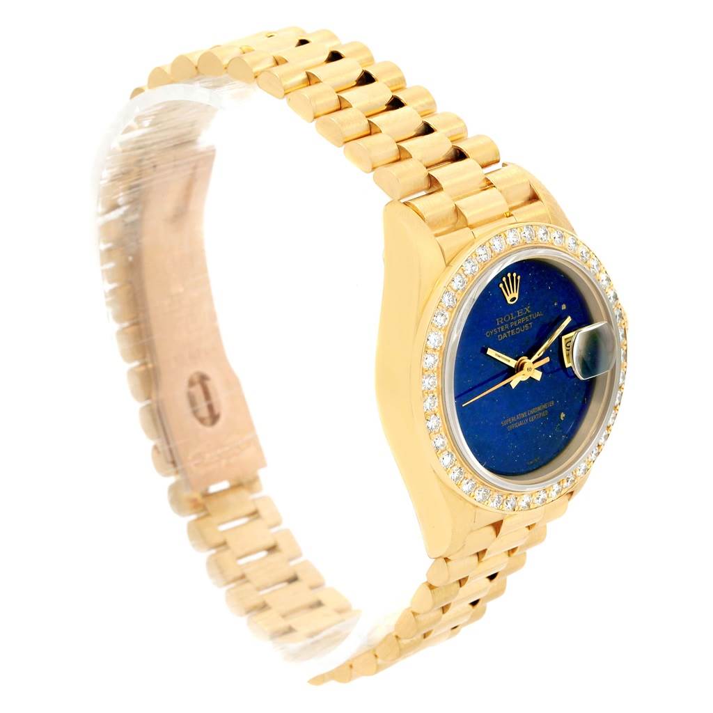 The Rolex President 69178 Women's Yellow Gold Blue Dial 69178 Women's Yellow Gold Blue Dial model watch is shown at an angle highlighting its gold bracelet, blue dial, and diamond-encrusted bezel.