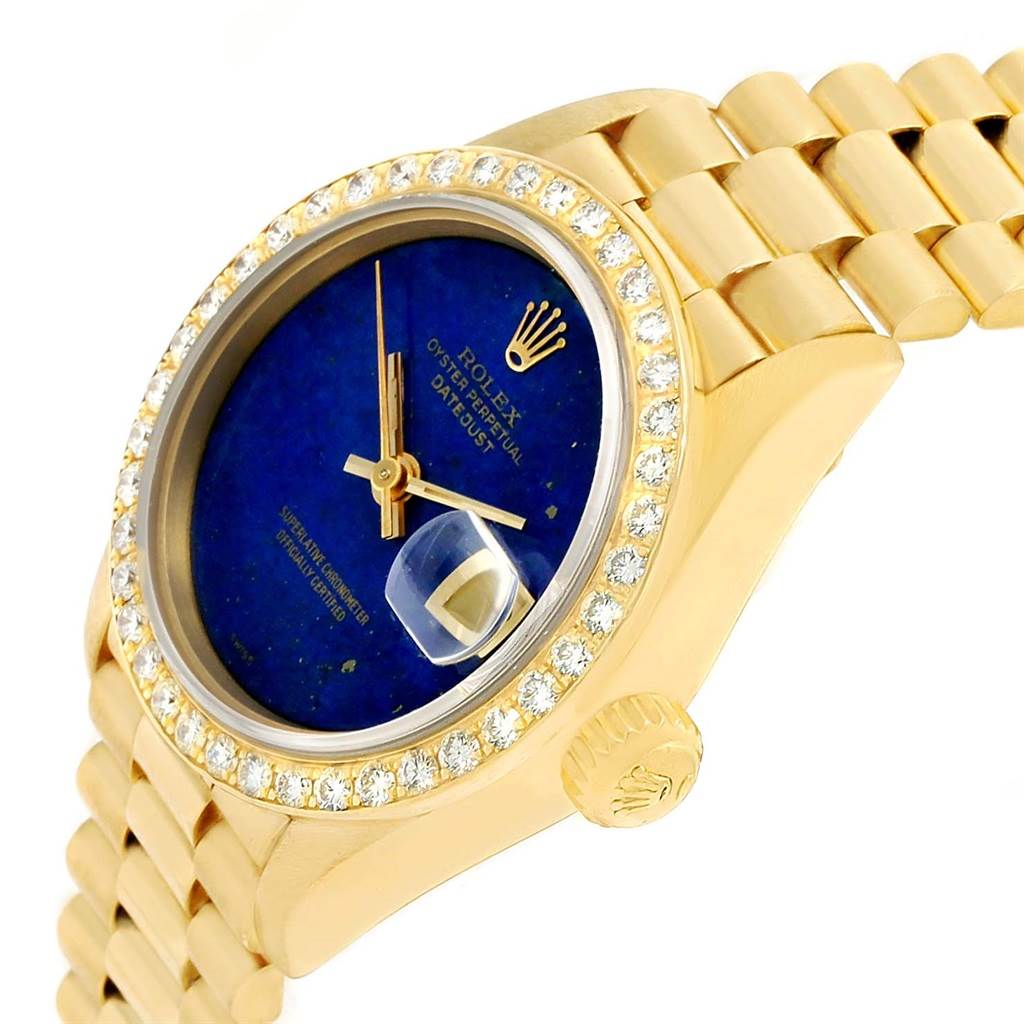 The Rolex President 69178 Women's Yellow Gold Blue Dial 69178 Women's Yellow Gold Blue Dial model watch is shown from a front-side angle, displaying the dial, bezel with diamonds, and part of the bracelet.
