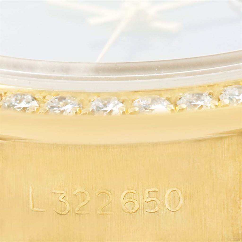 This close-up image shows the diamond bezel and part of the gold casing with the serial number of a Rolex President 69178 Women's Yellow Gold Blue Dial 69178 Women's Yellow Gold Blue Dial model watch.