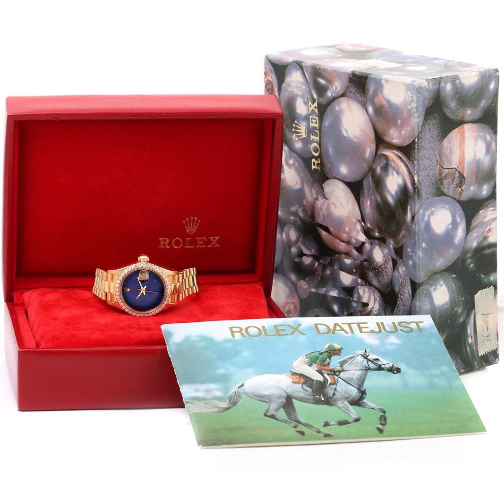 The image shows a Rolex President 69178 Women's Yellow Gold Blue Dial 69178 Women's Yellow Gold Blue Dial model watch in its box, accompanied by outer packaging and a booklet.