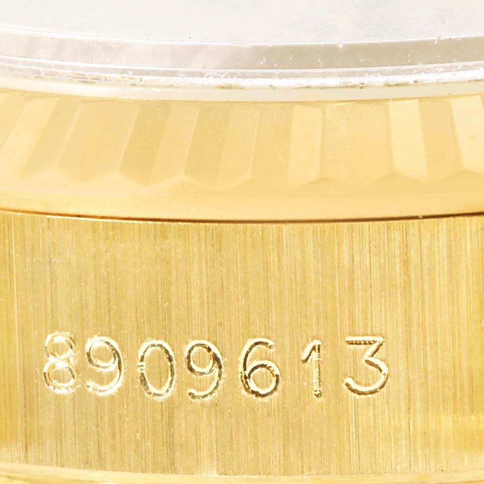 The image shows a close-up of the side of a Rolex President 69178 Women's Yellow Gold Champagne Dial 69178 Women's Yellow Gold Champagne Dial model's gold case with its serial number engraved.