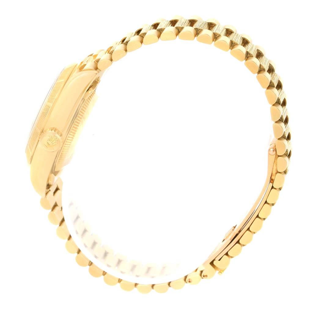 The image shows a side view of a Rolex President 69278 Women's Yellow Gold Champagne Dial 69278 Women's Yellow Gold Champagne Dial model watch, highlighting the crown and the characteristic gold bracelet.