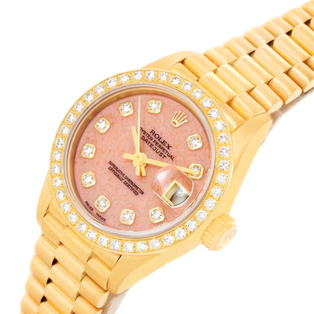 The image shows a gold Rolex President 69138 Women's Yellow Gold Pink Dial 69138 Women's Yellow Gold Pink Dial model watch from an angled top view, featuring a pink dial and a diamond bezel.