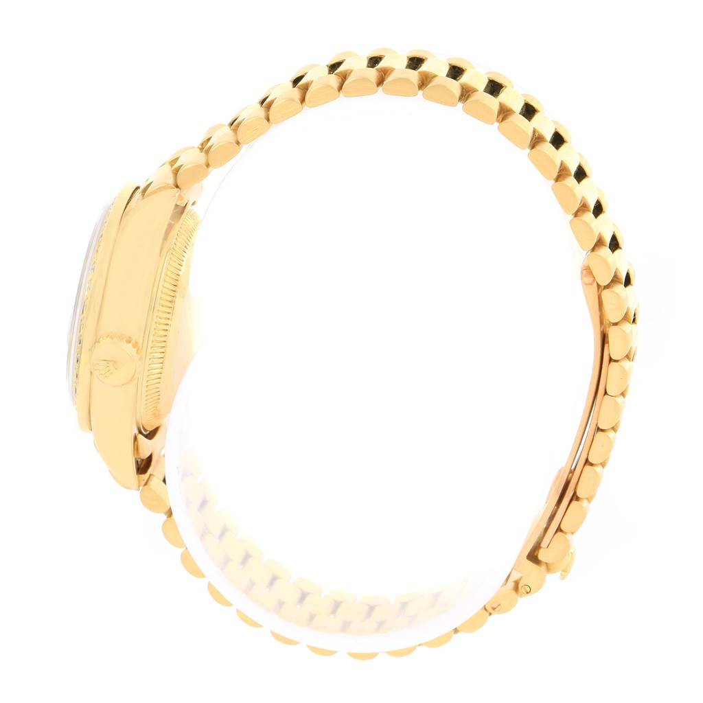 The image shows a side angle of the Rolex President 69138 Women's Yellow Gold Pink Dial 69138 Women's Yellow Gold Pink Dial model, highlighting its gold case and bracelet with a partially obscured crown.