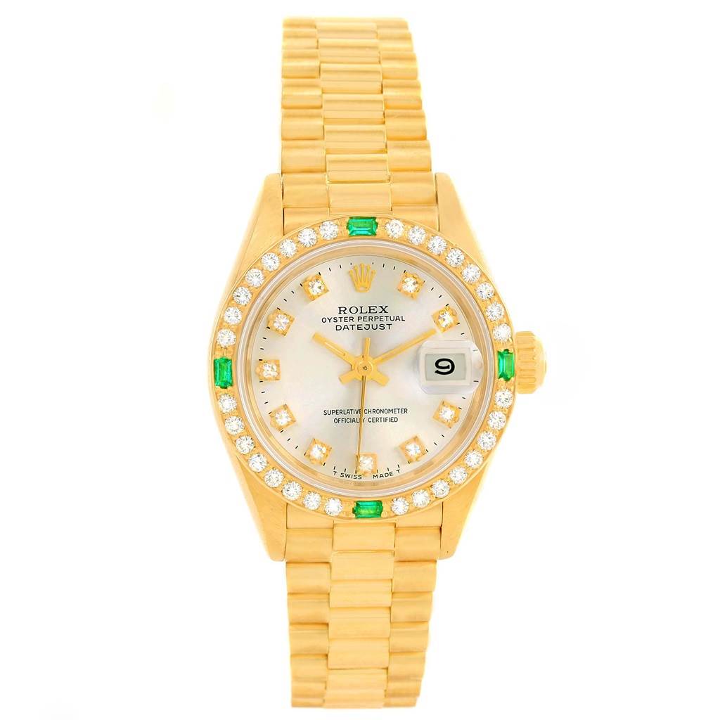 The image shows a Rolex President 69078 Women's Yellow Gold Silver Dial 69078 Women's Yellow Gold Silver Dial model watch featuring a gold bracelet, diamond and emerald bezel, and a date window.