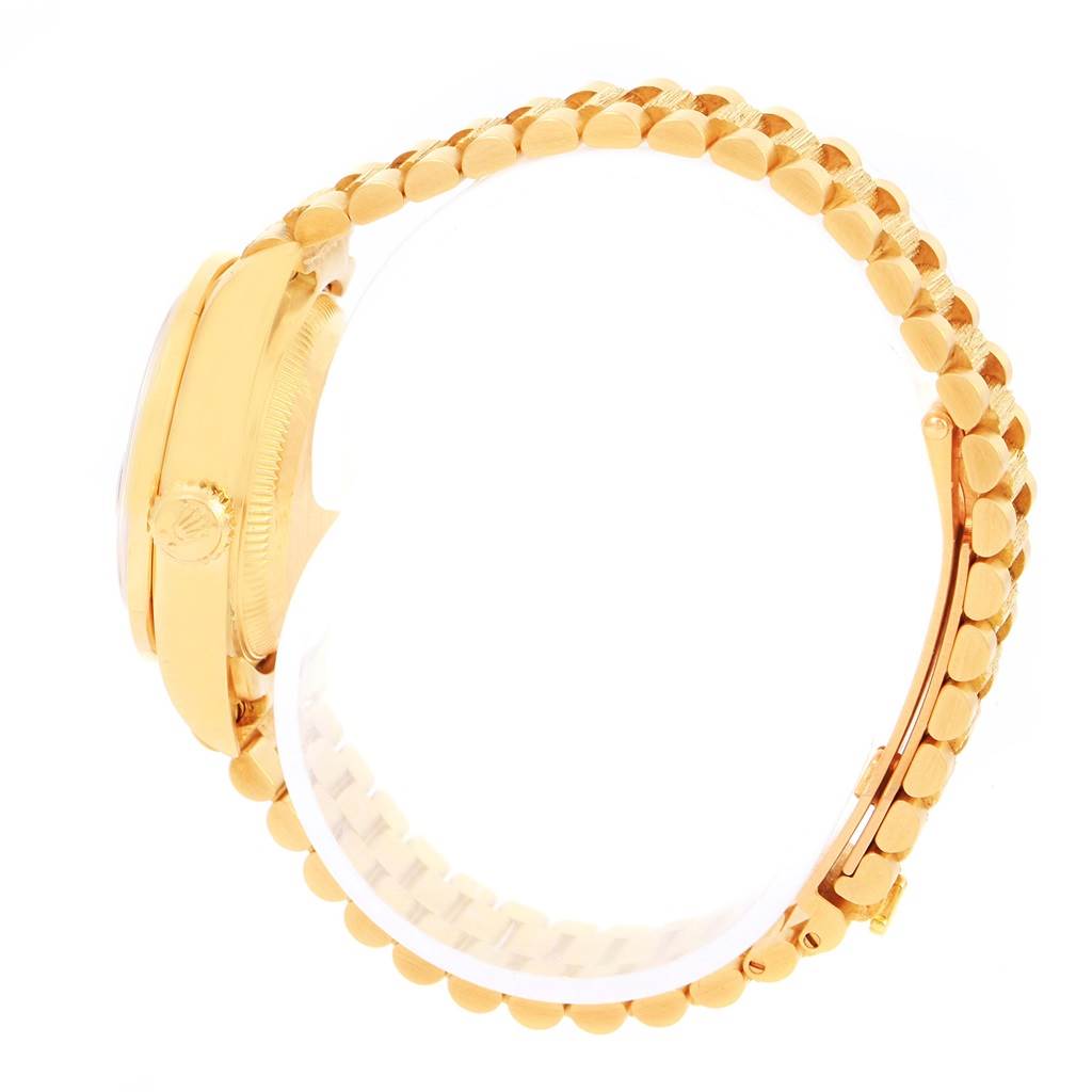 This side-angle view of the Rolex President 79288 Women's Yellow Gold Red Dial 79288 Women's Yellow Gold Red Dial model shows the profile of the watch case and the linked bracelet.