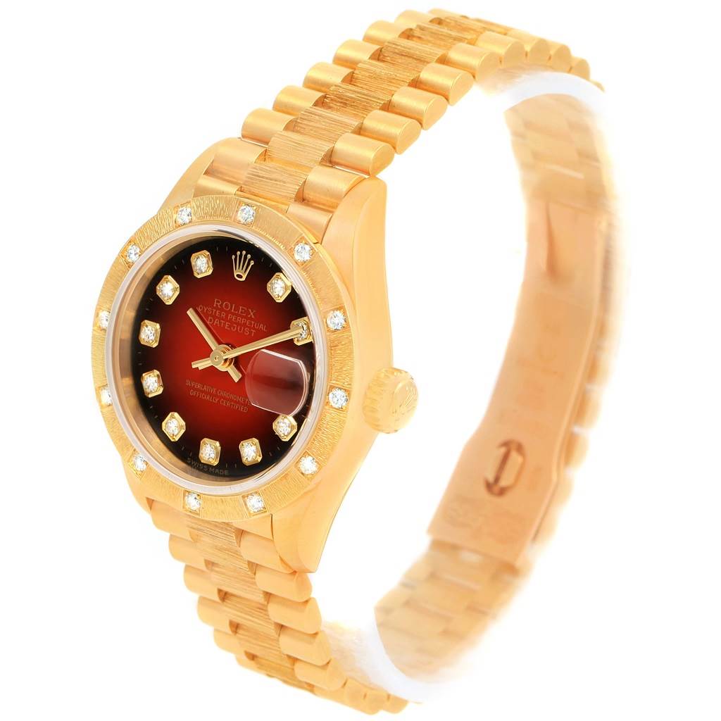 The image shows a Rolex President 79288 Women's Yellow Gold Red Dial 79288 Women's Yellow Gold Red Dial model watch at a three-quarter angle, highlighting the gold bracelet, case, and dial with diamond markers.