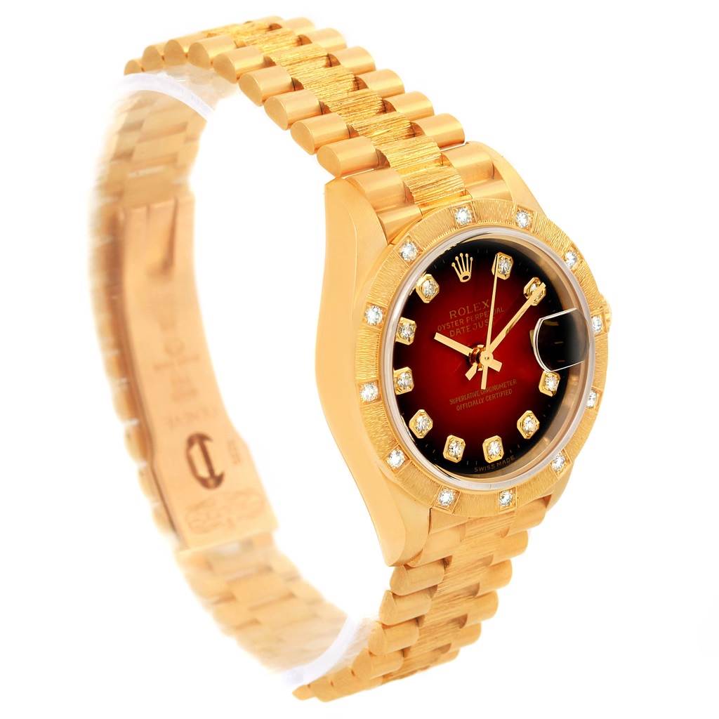 The image shows a Rolex President 79288 Women's Yellow Gold Red Dial 79288 Women's Yellow Gold Red Dial model watch at a slight angle, highlighting its gold bracelet, diamond-encrusted bezel, and dial.