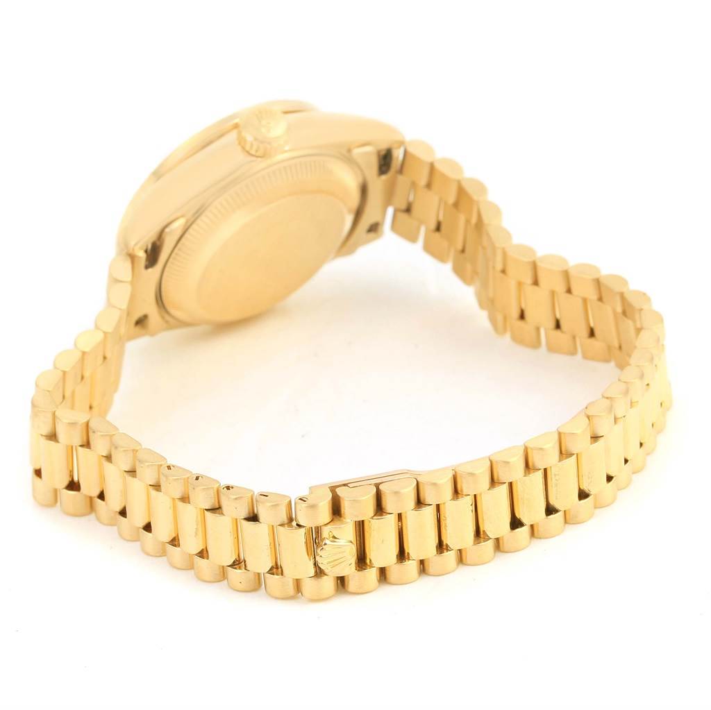 The image shows the back and partial side view of the gold Rolex President 69178 Women's Yellow Gold Champagne Dial 69178 Women's Yellow Gold Champagne Dial model with its distinctive bracelet and crown.