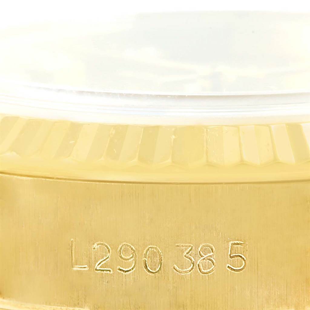 The image shows a close-up of the serial number and fluted bezel of the President model by Rolex.